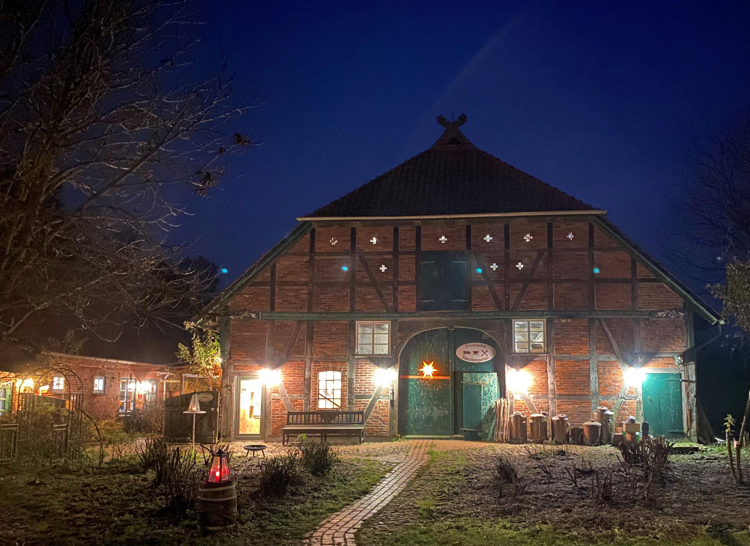 Das Bild zeigt das Haupthaus des Privelacker Paradiesgarten in dunkler Nacht in weihnachtlichem Lichterglanz.