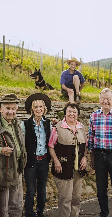 Das Bild zeigt die Inhaber und Mitarbeiter des Weingutes Stein vor einem ihrer Weinberge.